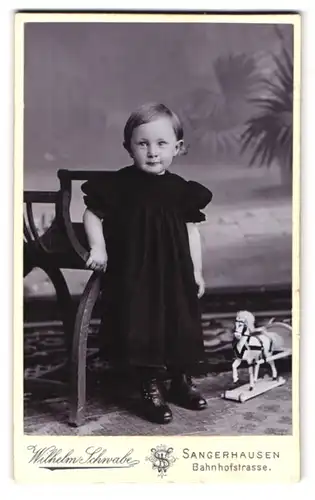 Fotografie Wilhelm Schwabe, Sangerhausen, Bahnhofstrasse, Mädchen im schwarzen Kleid und Spielzeugpferd