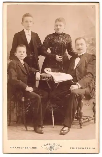 Fotografie Carl Euen, Berlin-SW, Oranien-Strasse 128, Portrait bürgerliche Familie mit Zeitung am Tisch