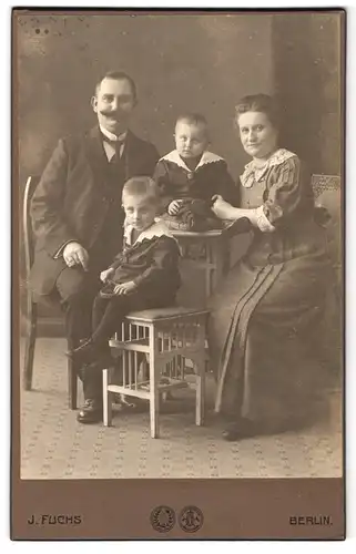 Fotografie J. Fuchs G. m. b. H., Berlin-N, Friedrichstrasse 138, Portrait bürgerliches Paar mit Sohn und Kleinkind