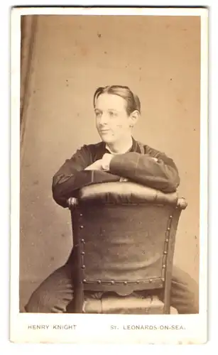 Fotografie Henry Knight, St. Leonards on Sea, 20, Grand Parade, Portrait modisch gekleideter Herr sitzt auf einem Stuhl