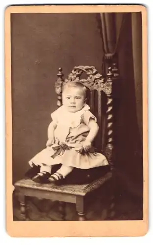 Fotografie J. Otten, Achim, Portrait kleines Kind im Kleid sitzt auf einem Stuhl