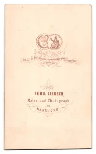 Fotografie Ferd. Liebsch, Hannover, Mann im Anzug mit Backenbart sitzt am Sekretär
