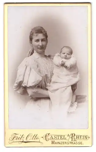 Fotografie Fritz Otto, Castel a. Rh., Mainzerstrasse, Portrait stolze Mutter im Kleid zeigt ihr Neugeborenes