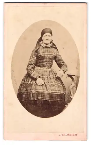 Fotografie J. Th. Meier, Marienbad, Portrait alte Frau im karierten Kleid mit Kopftuch