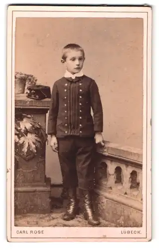 Fotografie Carl Rose, Lübeck, König-Strasse 53, Portrait kleiner Knabe im Anzug mit Militärmütze