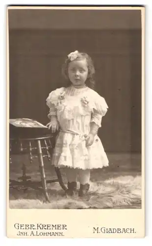 Fotografie Gebr. Kremer, M. Gladbach, Crefelderstrasse 88, Portrait kleines Mädchen im weissen Kleid mit Haarschleife