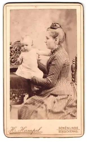 Fotografie H. Hampel, Schönlinde, Portrait Mutter im gestreiften Kleid mit Hochsteckfrisur ziegt stolz ihr Kind