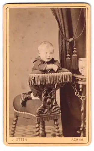 Fotografie J. Otten, Achim, Portrait Kleinkind im Anzug posiert auf einem Fotografenstuhl