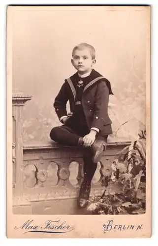 Fotografie Max Fischer, Berlin, Invalidenstrasse 164, Portrait Knabe im Matrosenanzug auf einer Brüstung