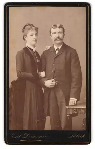 Fotografie Carl Drümmer, Lübeck, Breitestrasse 24, Portrait Mann und Frau im Anzug und Biedermeierkleid mit Halskette