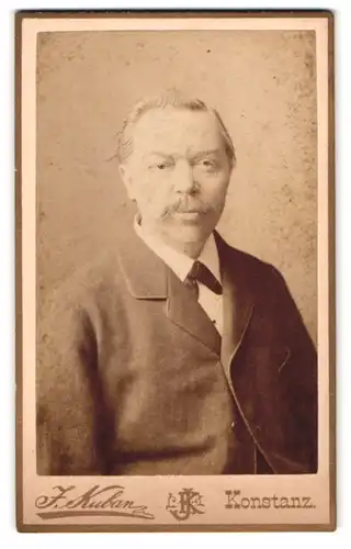Fotografie J. Kuban, Konstanz, Hieronymusgusse, Portrait älterer Herr im Anzug mit Fleige und Walrossbart