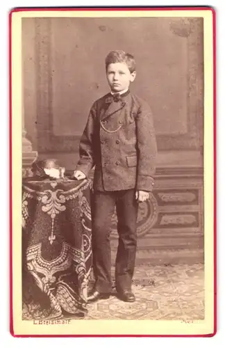 Fotografie L. Bresslmair, Meran, Portrait junger Knabe im Anzug mit Fliege im Atelier