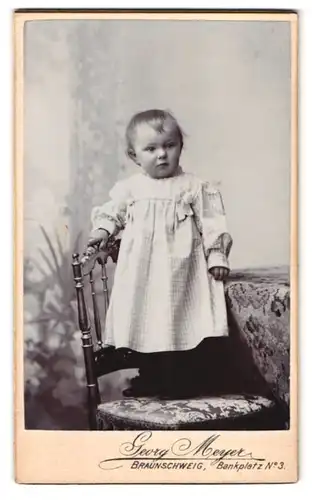 Fotografie Georg Meyer, Braunschweig, Bankplatz 3, Portrait Kleinkind im karierten Kleid steht auf einem Stuhl