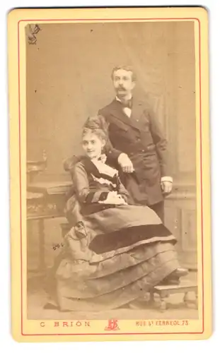 Fotografie C. Brion, Marseille, Rue St. Ferreol 73, Portrait Mann und Frau im Anzug ind Biedermeierkleid im Atelier