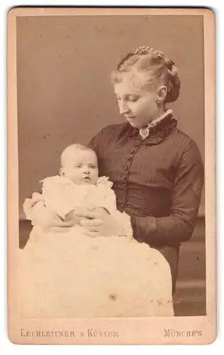 Fotografie Lechleitner & Küster, München, Amalienstr. 6, junge Mutter mit Baby im Taufkleid
