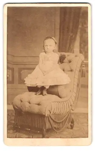 Fotografie Adolph Zeisig, Perleberg, Mädchen im weissen Kleid auf Sessel stehend