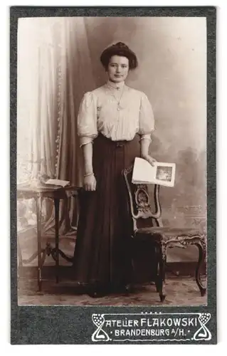 Fotografie Atelier Flakowski, Brandenburg / Havel, junge Dame mit Katalog im Foto-Atelier