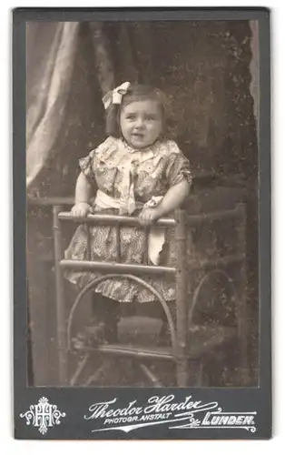 Fotografie Theodor Harder, Lunden, Portrait lächelndes kleines Mädchen mit Schleife im Haar