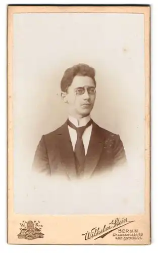 Fotografie Wilhelm Stein, Berlin, Chausseestr. 66, Portrait Bursche mit Zwicker trägt Anzug und Krawatte