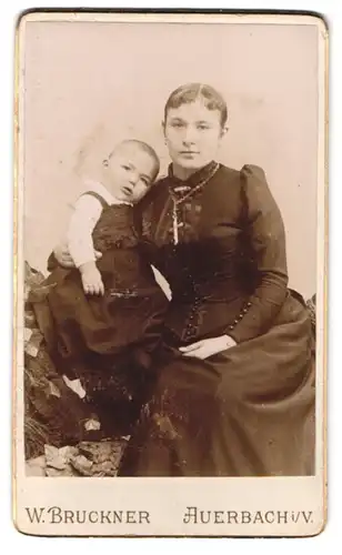 Fotografie W. Bruckner, Auerbach i. V., Portrait junge Mutter im Kleid mit Kleinkind im Kleidchen, Kreuzkette