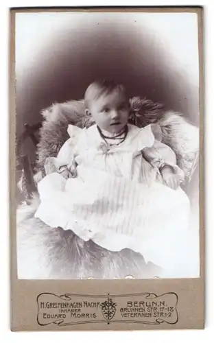 Fotografie H. Greifenhagen Nachf., Berlin, Brunnenstrasse 17-18, Portrait Kleinkind im gestreiften Kleid mit Perlenkette