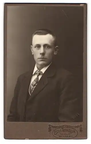 Fotografie Ester Andersson, Gnosjö, Portrait junger Mann im schwarzen Anzug mit Krawatte