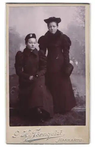 Fotografie G. H. Törnquist, Markaryd, Portrait zwei Damen der Heilsarmee in Wintermänteln mit Muff