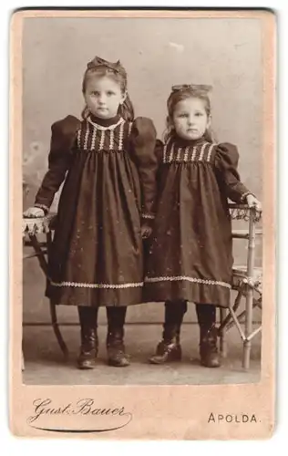 Fotografie Gust. Bauer, Apolda, Obere Bahnhofstrasse 9, Portrait zwei Mädchen in schwarzen Kleidern mit Haarschleifen