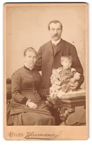 Fotografie Atelier Hurmann, Leipzig, Wintergartenstr. 4, Portrait Vater und Mutter mit Kind im Kleid und Puppe im Arm