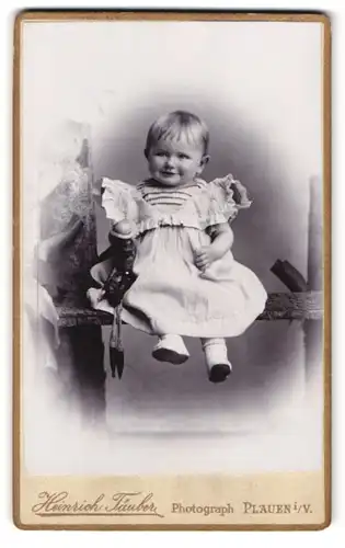 Fotografie Heinrich Täuber, Plauen i. V., oberer Graben 17, Portrait kleines Mädchen im weissen Kleid mit Puppe