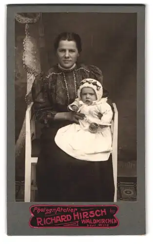 Fotografie Richard Hirsch, Waldkirchen i. bayr. Wald, Portrait Mutter im dunkeln Kleid mit Baby auf Schoss, Mutterglück