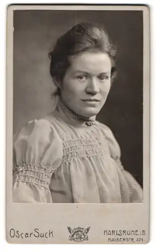 Fotografie Oscar Suck, Karlsruhe i. B., Kaiserstr. 223, Portrait Dame im hellen kleid mit Brosche schaut skeptisch