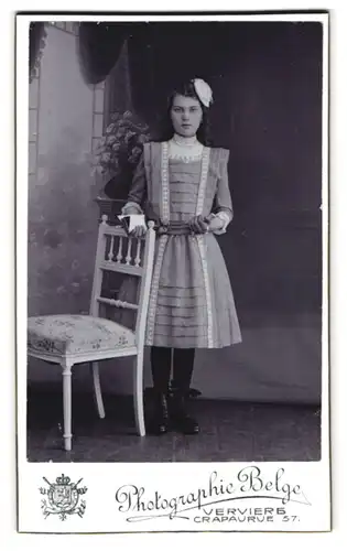Fotografie Photographie Belge, Verviers, Crapaurue 57, Portrait Mädchen im Kleid mit Haarschleife schaut streng