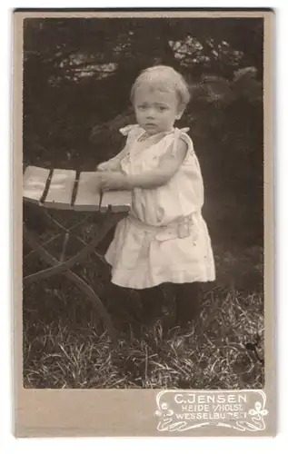 Fotografie C. Jensen, Heide i. Holst., Wesselbuden, Kleinkind in ärmellosem Kleid