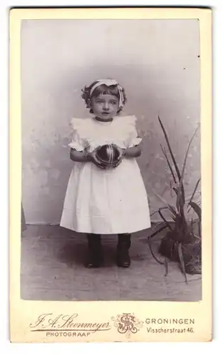 Fotografie J. A. Steenmeyer, Groningen, Visscherstraat 46, kleines Mädchen hält eine schmuckvolle Kugel