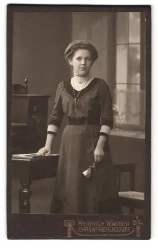 Fotografie Heinrich Wagner, Ehrenfriederdorf, Chemnitzerstrasse, Mädchen in dunklem, hochgeschlossenem Kleid mit Rose