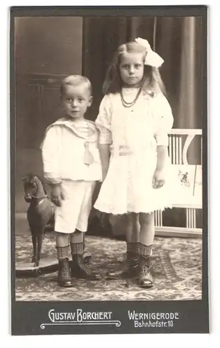 Fotografie Gustav Borchert, Wernigerode, Bahnhofstr. 10, Portrait Bruder und Schwester in weisser Kleidung mit Holzpferd