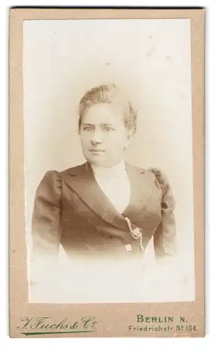 Fotografie J. Fuchs & Co., Berlin, Friedrichstrasse 108, Portrait Dame im Kleid mit Brosche
