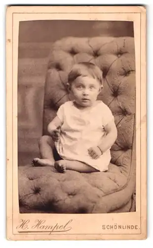Fotografie H. Hampel, Schönlinde, aufgeregtes Baby auf Sessel sitzend