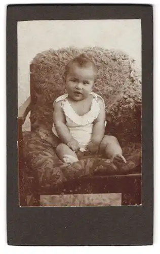 Fotografie unbekannter Fotograf und Ort, Kleines Kind im weissen Hemd auf einem Stuhl