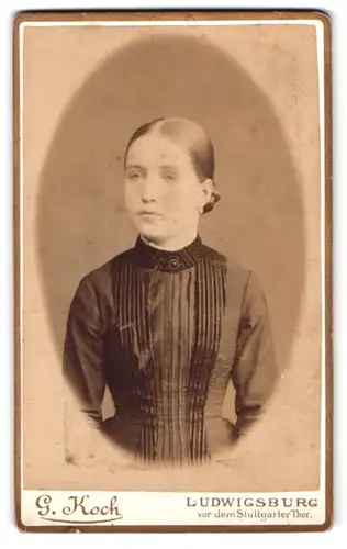 Fotografie G. Koch, Ludwigsburg, Junge Dame im dunklen Kleid mit zusammengesteckten Haaren, Ohrringen
