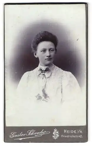 Fotografie Gustav Schwedes, Heide i. H., Friedrichstr. 42, Dame im weissen Kleid mit Schleife und Föhnfrisur