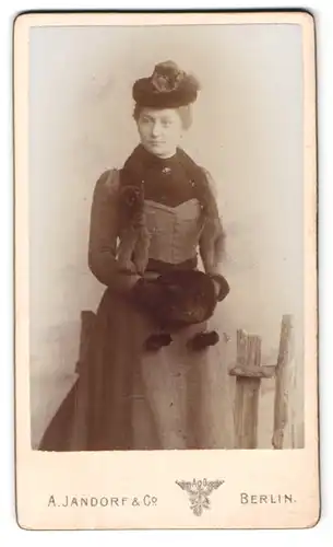 Fotografie A. Jandorf & Co., Berlin, Spittelmarkt 16, Portrait Dame mit Hut und Handmuff in tailliertem Kleid