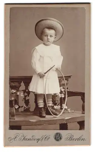 Fotografie A. Jandorf & Co., Berlin, Spittelmarkt 1, Portrait Kleiner Junge mit Hut und Reifen im Kleidchen