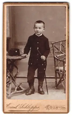Fotografie Emil Schlippe, Cölln a. Elbe, Portrait Junge mit Stiefeln und hochgeknöpftem Jackett