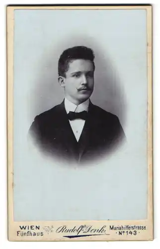 Fotografie Rudolf Denk, Wien, Mariahilferstr. 143, Junger Mann mit Haartolle, Schnurrbart und Fliege
