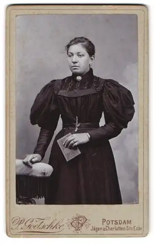 Fotografie P. Goetschke, Potsdam, Ecke Jäger- und Charlotten-Strasse, Frau in schwarzem Kleid und mit Buch
