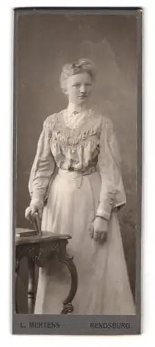 Fotografie L. Mertens, Rendsburg, Portrait hübsch gekleidete Dame mit Buch in der Hand