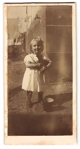 Fotografie unbekannter Fotograf und Ort, Portrait kleines Mädchen im Kleid mit Spieltier