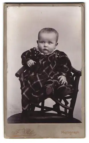 Fotografie F. Petz, Duderstadt, Portrait Kleinkind im karierten Kleid sitzt auf einem Kinderstuhl